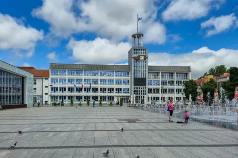 Plac miejski w Koszalinie, stare miasto, z ratuszem i fontannami w tle.