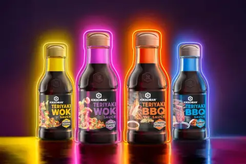 Fyra flaskor Kikkoman teriyaki marinad i olika smaker, omgivna av neonljus.
