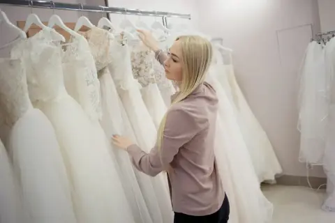 Blondynka wybiera suknię ślubną w salonie sukien.