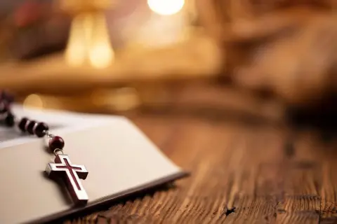 Różaniec na otwartej księdze, symbol wiary. Czasem nawet dziwne imiona świętych prowadzą do głębokiej refleksji.