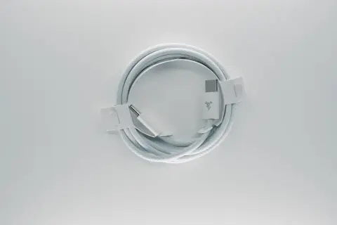 Biały kabel z końcówkami USB-C, zgodny ze standardem USB C, zwinięty na białym tle.