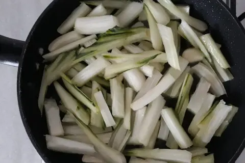 Coste di sedano tagliate a bastoncini e pronte per essere saltate in padella.