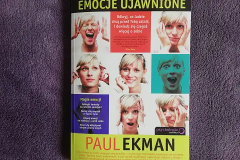 Okładka książki "Emocje ujawnione" Paula Ekmana, prezentująca różne ludzkie emocje.