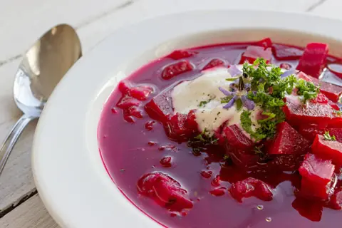 Herzhafte Rote-Bete-Suppe mit einem Klecks Sauerrahm und frischer Petersilie. Ein köstliches Gericht, das an Borretsch Rezepte erinnert.