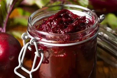 Słoik z buraczanym chutney, obok świeże buraki. Zastanawiasz się, chutney co to? To pyszny dodatek.