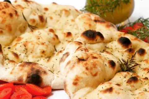 Crescia marchigiana senza strutto, dorata e fragrante, con pomodorini e rosmarino.