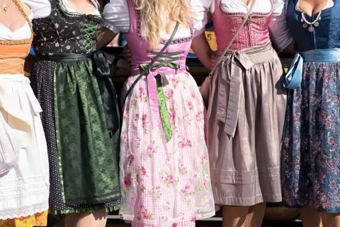 Fünf Frauen in farbenfrohen Chiemgauer Trachten, Dirndl mit Blumenmuster und Spitzenbesatz.