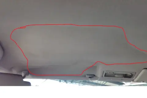 Odklejająca się podsufitka? Zobacz, jak przykleić podsufitkę bez demontażu, zaznaczony obszar pokazuje problem.