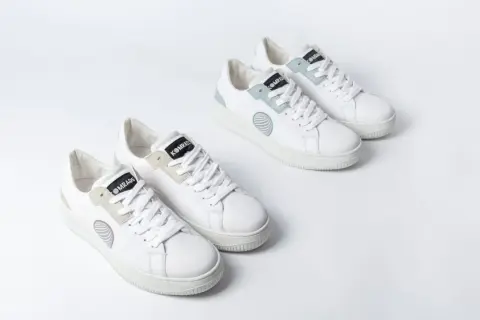 Zwei Paar weiße trend sneaker mit hellgrauen und mintgrünen Akzenten, auf weißem Hintergrund.