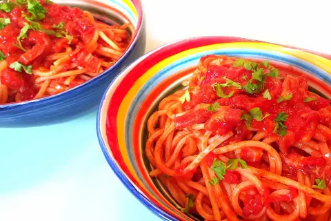 Zwei Schüsseln mit Spaghetti Amatriciana alla Nonna, garniert mit Petersilie.