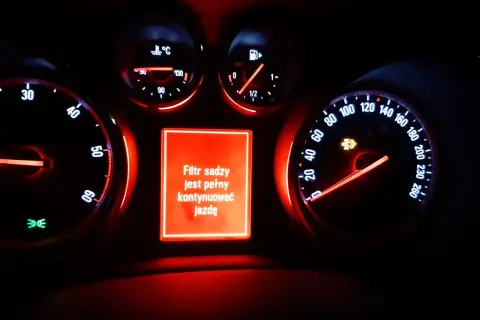 Na desce rozdzielczej Opla świeci się czerwona kontrolka dpf, informując o zapchanym filtrze cząstek stałych i konieczności kontynuowania jazdy.