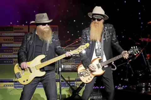 Due musicisti con lunghe barbe e cappelli suonano sul palco. Uno suona un basso giallo, l'altro una chitarra. È più facile suonare il basso o la chitarra?