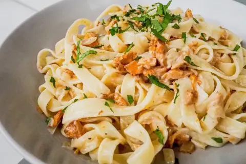 Tagliatelle w kremowym sosie kurkowym, posypane świeżą natką pietruszki. Pyszne danie, które zachwyci każdego miłośnika grzybów.