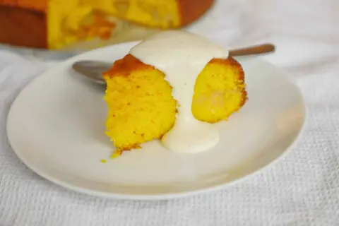 En bit saftig saffranskaka i sockerkaksform, toppad med len vaniljsås. Perfekt för fikat!