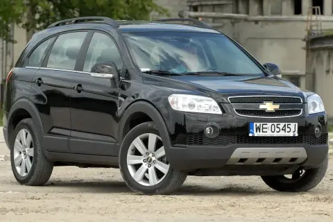 Czarny Chevrolet Captiva 2.0 diesel na tle opuszczonego budynku.