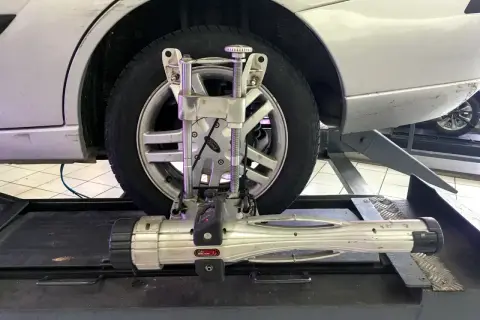 Réglage du parallélisme voiture avec un appareil de mesure sur une roue.