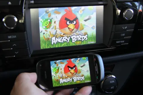 Telefon z grą Angry Birds wyświetla ten sam obraz co ekran samochodu, tworząc efekt mirror link.