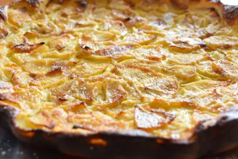 Une flognarde aux pommes dorée et appétissante, saupoudrée de sucre glace. Un délice fait maison.