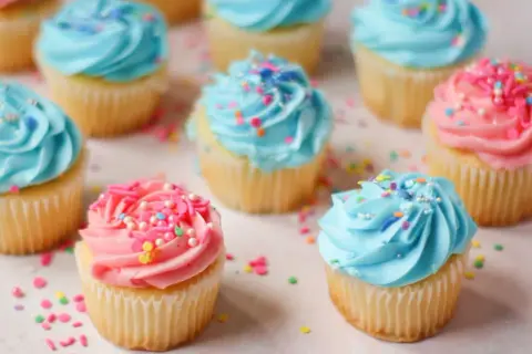 Söta cupcakes med blå och rosa frosting, strössel. Perfekt för ett gender reveal tårta recept.