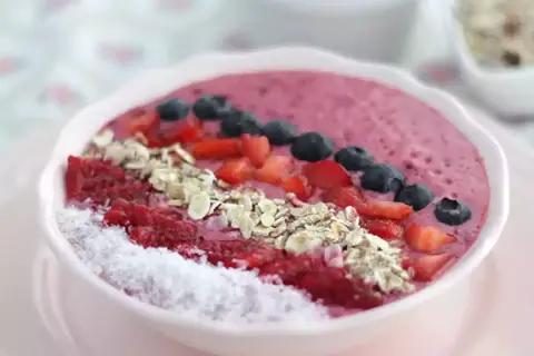 En rosa smoothie bowl med hallon, blåbär, jordgubbar, kokosflingor och granola. En perfekt start på dagen!