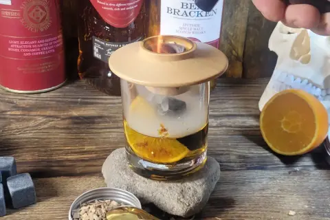 Dymiący drink z whisky, pomarańczą i kamieniami do napojów. Idealny sposób, jak zrobić drinka z whisky, by nadać mu głębi smaku.