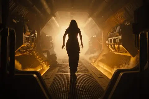 Silhouettierte Frau geht durch einen düsteren, rauchigen Korridor. Ein Blick auf den Alien Romulus Stream.