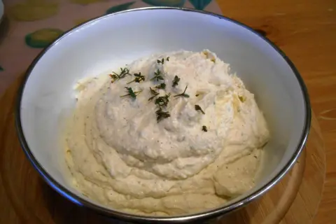 Puszysta pasta jajeczna z chrzanem, udekorowana gałązkami tymianku, w białej misce. Idealna na kanapki.