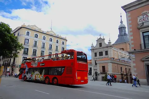 Roter Doppeldeckerbus mit Touristen fährt durch Madrid. Tolle Madrid Tipps für Sightseeing!