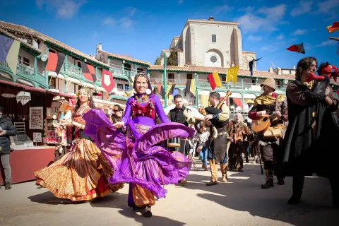 Danza y música en la feria medieval de Madrid. Bailarinas con trajes coloridos y músicos con instrumentos de época animan la celebración.