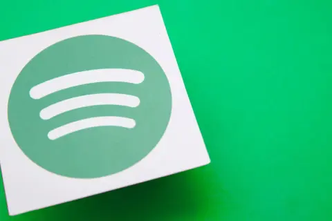 A white square with the green Spotify logo sits on a bright green surface, hinting at the platform's popularity and its impressive spotify stream count.