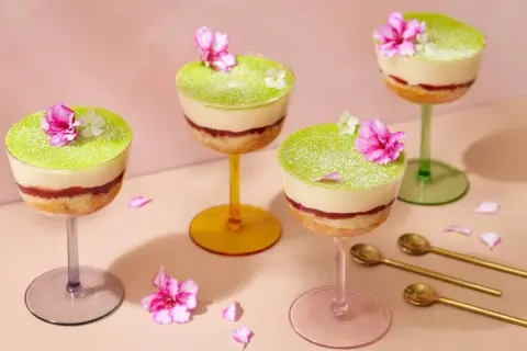 Fyra vackra prinsesstårtor i glas, dekorerade med blommor och pudrade med florsocker. En festlig dessert!