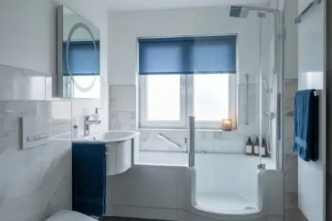 Modernes Bad mit Dusche und Wanne. Ein Beispiel, wann muss Vermieter Bad renovieren: bei starkem Verschleiß oder Mängeln.