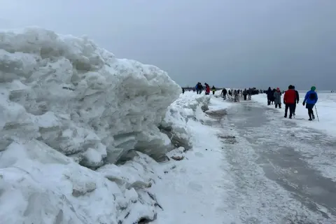 Mikoszewo: imponujące góry lodowe na plaży, ludzie spacerują po zamarzniętym brzegu.
