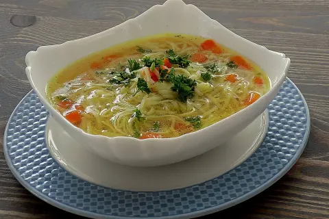 Aromatyczna zupa na rosole z makaronem nitki i marchewką, udekorowana natką pietruszki. Idealna na chłodne dni.