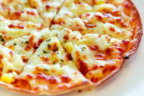 Pyszna, gorąca pizza z patelni, z ciągnącym się serem i ziołami, gotowa do podania.