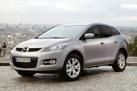 Srebrna Mazda CX-7 2.3 Turbo na tle panoramy miasta.