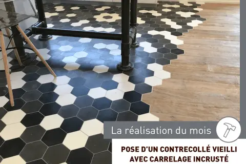 Sol avec un mélange de carrelage hexagonal noir, blanc et gris, et de parquet en bois.