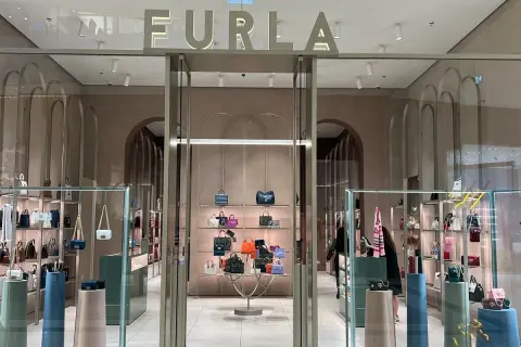 Elegancki butik Furla, gdzie furla co to za marka jest widoczna na szyldzie. W środku mnóstwo torebek i akcesoriów.