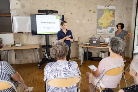 Une conférencière présente une initiation à la généalogie aux archives départementales du Lot.