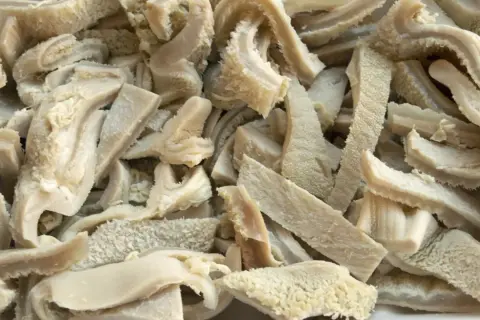 Ein Haufen gekochter Kutteln, die für die Zubereitung von Gerichten wie "Kutteln, was ist das?" vorbereitet werden.