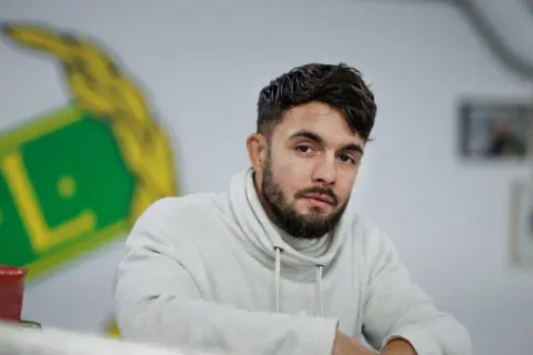 Anthony Yigit, en svensk boxare, blickar mot kameran i en ljus studio.
