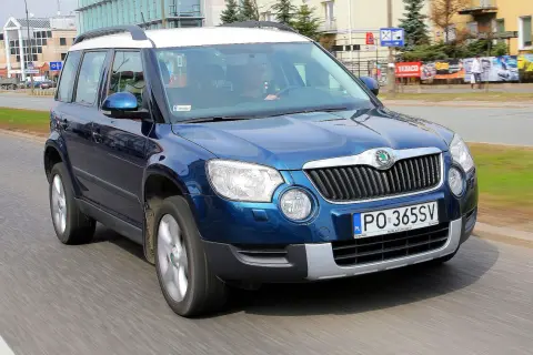 Niebieska Skoda Yeti na drodze. Kierowca w środku. Wiele pozytywnych skoda yeti opinie o tym modelu.