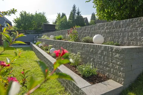 Moderne Gartenmauer mit Terrassierung und dekorativen Kugeln. Tolle Ideen für Gartenmauern, die Struktur und Stil verleihen.