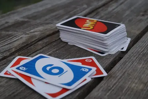 Karty UNO leżą na drewnianym stole. Czas na grę i poznanie uno flex zasady!