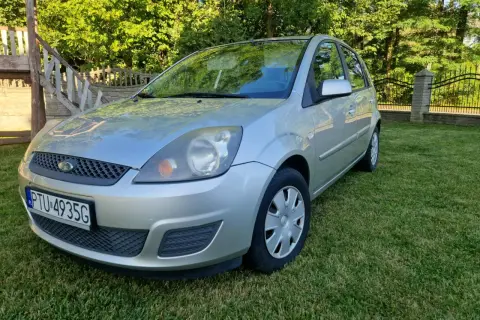 Srebrny Ford Fiesta Mk5 na trawniku, z widocznym numerem rejestracyjnym PTU 4935G.