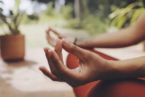 Manos en posición de meditación, con el pulgar e índice unidos, un mudra de energía.