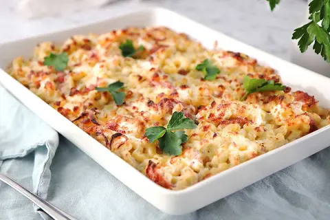 En krämig gratäng med makaroner, ost och bacon, perfekt för ett gott ostsås recept. Garnerad med färsk persilja.