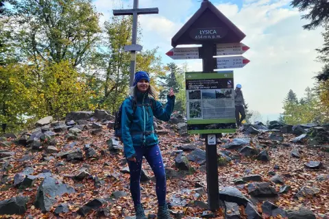 Uśmiechnięta turystka na szczycie Łysica, 614 m n.p.m. Jesienne liście i kamienie tworzą malowniczy krajobraz.