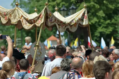 Procesja Bożego Ciała. Czy to dzień wolny od pracy? Ludzie obserwują, niektórzy filmują telefonami.