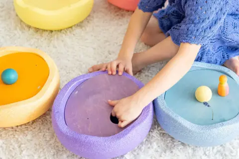 Kind spielt mit bunten Stapelsteinen und erforscht verschiedene Stapelsteine Spielideen.